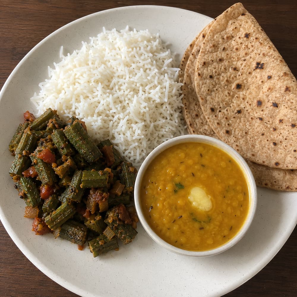 A home-style lunch: steamed rice, bhindi sabzi, toor dal with ghee, and chapati